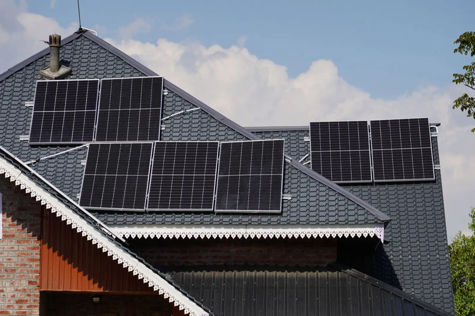 Einfamilienhaus mit dunklem Ziegeldach und Photovoltaik-Modulen auf zwei Dachflächen